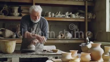 经验丰富的陶工正在车间里用陶土制造器皿. 生产食品，手工制作
